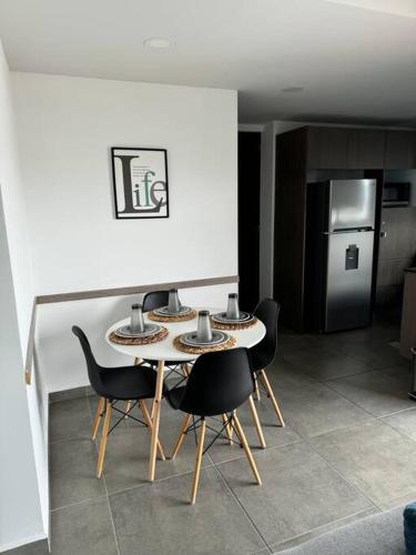 a table and chairs in a kitchen with a refrigerator at Amazing Loft Plaza Mayor Zone AC Wifi CoWorking in Miravalle