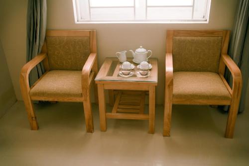 a table with two chairs and a tea set on it at Phương Phương 2 Hotel in Ha Tinh
