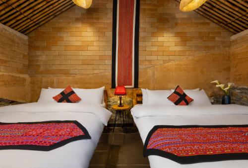 two beds sitting next to each other in a room at Sapaxa Spring Garden Ecolodge in Sa Pa