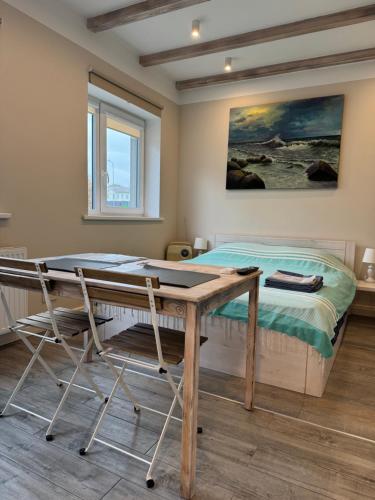 a bedroom with a desk and a bed with a painting at Old Center Apartment in Liepāja