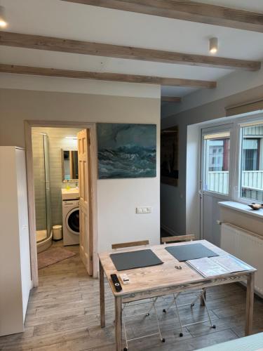 a living room with a table and a kitchen at Old Center Apartment in Liepāja