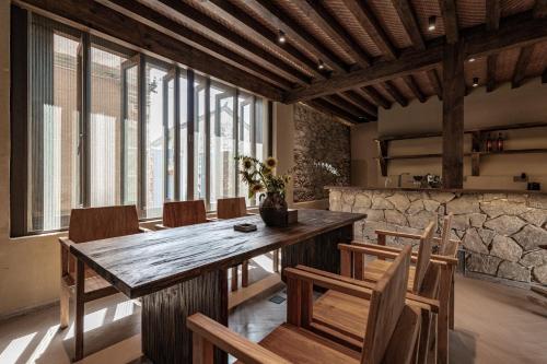 a dining room with a wooden table and chairs at 大理阳和光隐奢四合院 in Dali