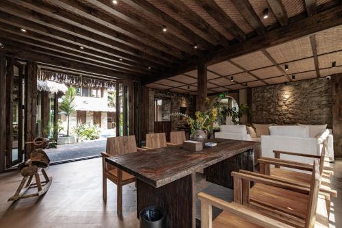 a living room with a wooden table and chairs at 大理阳和光隐奢四合院 in Dali