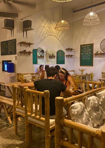 a group of people sitting at a table in a restaurant at Vela Terraces Hotel in Coron