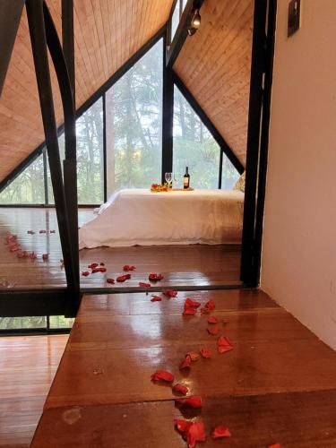 a room with a bed and roses on the floor at Cabaña Onix - La Pascana Ecolodge in Mazo