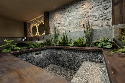 a bathtub in the middle of a room with plants at 大理阳和光隐奢四合院 in Dali