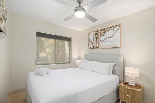 a bedroom with a white bed and a window at Sawtell Beach Ocean Sands 3 - Opposite Main Beach and short stroll to Coffee Shops and Restaurants! in Sawtell