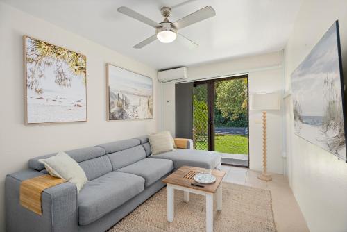 un soggiorno con un divano e un tavolo di Sawtell Beach Ocean Sands 3 - Opposite Main Beach and short stroll to Coffee Shops and Restaurants! a Sawtell