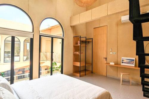 a bedroom with a bed and a large window at Cottonwood Villa Magnolia B - Jacuzzi Billyard BBQ in Bandung