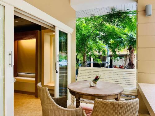 a patio with a table and chairs and a window at Amity Beach Resort in Lamai