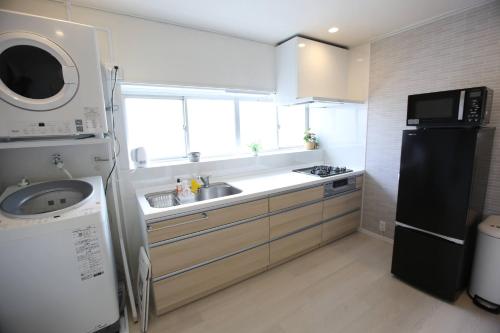 a kitchen with a sink and a refrigerator at Breath of the Sea Katakai in Katakai