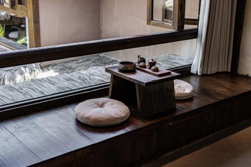 a room with two beds and a table with a stool at 大理阳和光隐奢四合院 in Dali