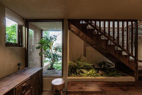 a room with a staircase with plants and a window at 大理阳和光隐奢四合院 in Dali