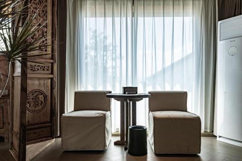 a room with two chairs and a table and a window at 大理阳和光隐奢四合院 in Dali