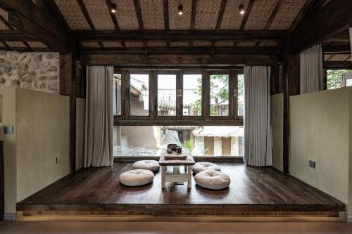 a living room with pillows on a wooden floor at 大理阳和光隐奢四合院 in Dali
