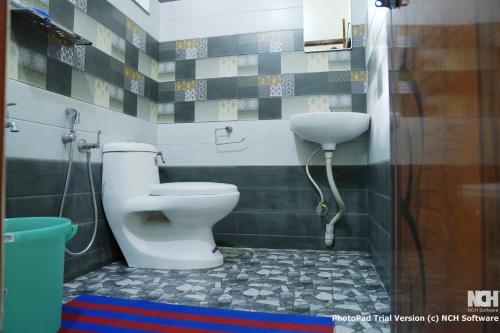 a bathroom with a toilet and a sink at Bindara Home Stay in Kottayam