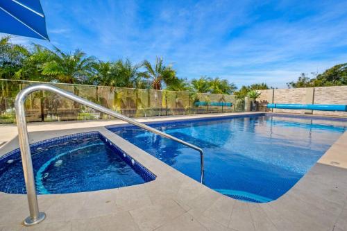 a large swimming pool with blue water in a yard at Unit 3 - Avoca Palms Resort in Avoca Beach
