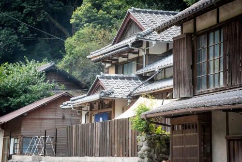 a row of houses with a fence in front of them at 自然と遊ぶ古民家宿 石鎚別荘ハレとあお in Komatsu