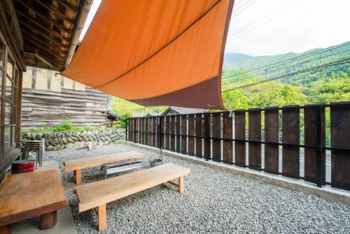 a balcony with benches and a view of the mountains at 自然と遊ぶ古民家宿 石鎚別荘ハレとあお in Komatsu