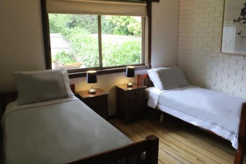 two beds in a room with a window at Church St in Bright