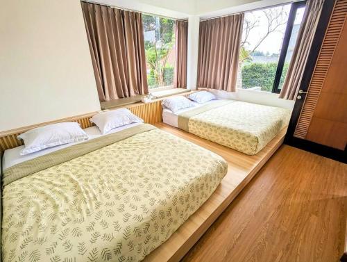deux lits assis dans une pièce avec une fenêtre dans l'établissement Cottonwood Villa Zamrud - Pingpong BBQ Pool Disney, à Tegalharendong