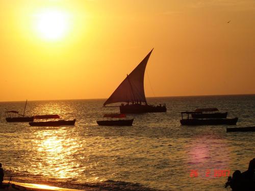 a group of boats in the ocean at sunset at Princess Salme Inn in Zanzibar City