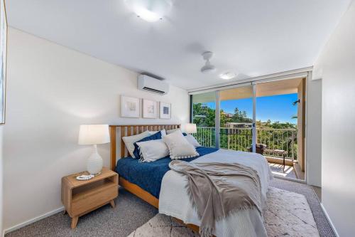 a bedroom with a bed and a balcony at Large, Luxurious Townhouse Stunning Oceanviews in Airlie Beach