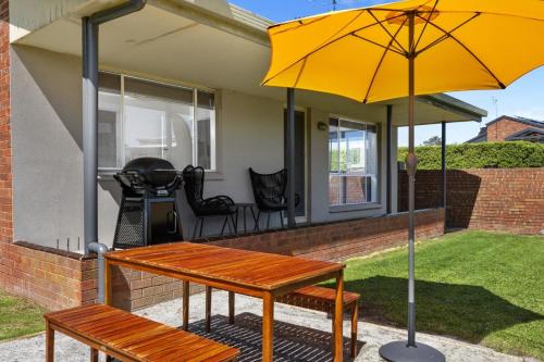 a bench and an umbrella on a patio at BIG4 Ingenia Holidays Inverloch in Inverloch