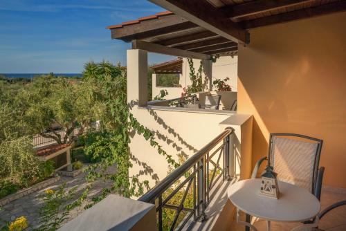 a balcony of a house with a table and chairs at Olga Studios in Vasilikos
