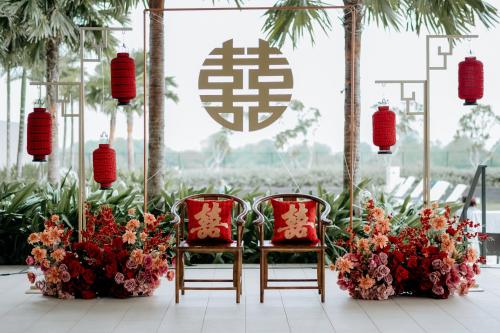 two chairs and a table with flowers and lanterns at Courtyard by Marriott Melaka in Melaka