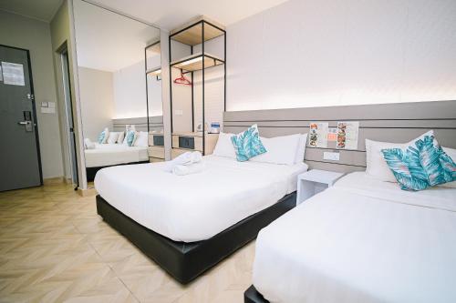 a hotel room with two beds and a mirror at Kingston Hotel 2 - Setapak in Kuala Lumpur