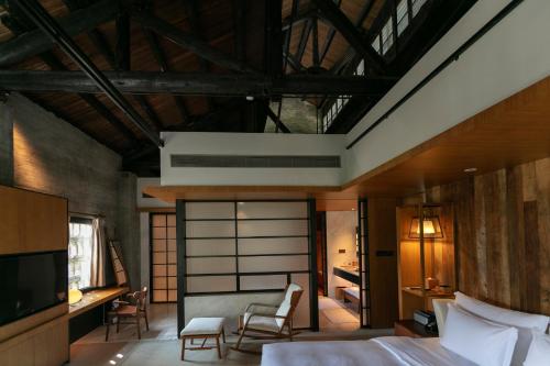 a bedroom with a bed and a desk and a tv at Yangshuo Sugar House in Yangshuo
