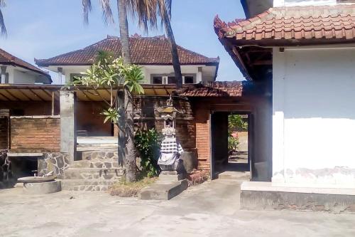a house with a statue in front of it at Guest House Surya Ayu Permai Buleleng Mitra RedDoorz in Panji