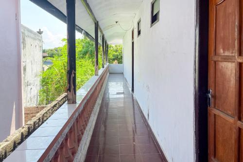 an empty hallway of a building with a door at Guest House Surya Ayu Permai Buleleng Mitra RedDoorz in Panji