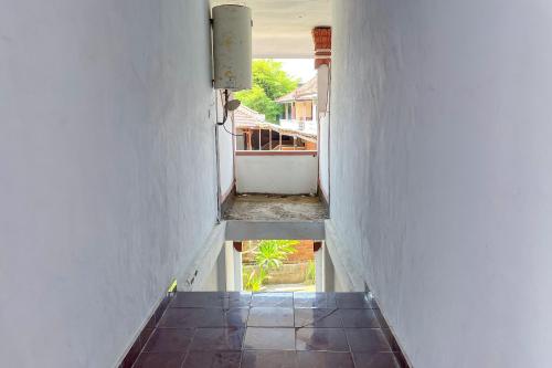 a hallway with a staircase leading to a room at Guest House Surya Ayu Permai Buleleng Mitra RedDoorz in Panji