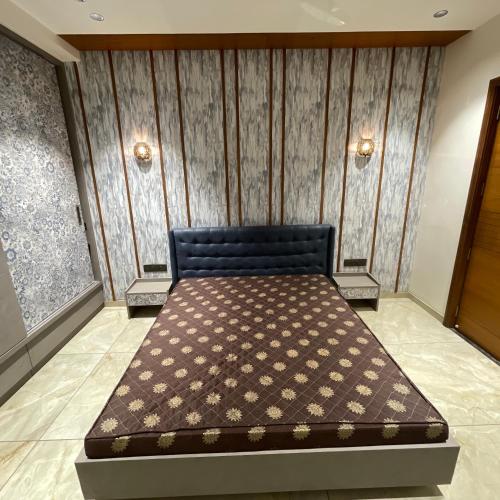 a bed in a room with a wall at Nisarg’s stays in Ahmedabad