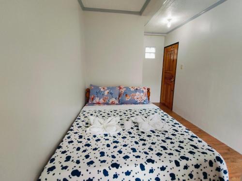 a bedroom with a bed with a blue and white comforter at Bogah Lodge in Banaue