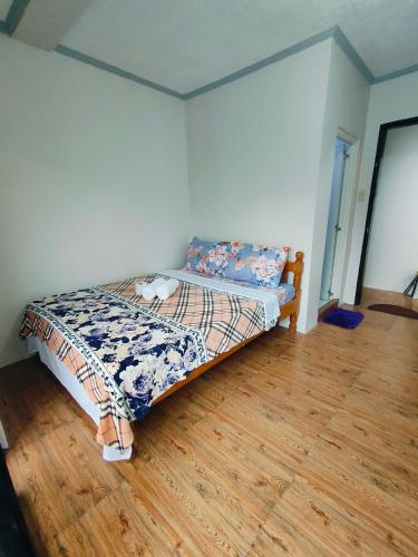 a bed in a room with a wooden floor at Bogah Lodge in Banaue