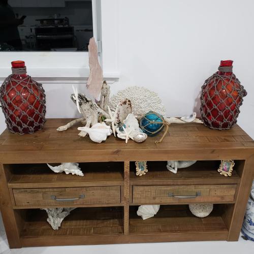 a wooden table with two vases on top of it at Magnolia's By The Sea in Big Pine Key