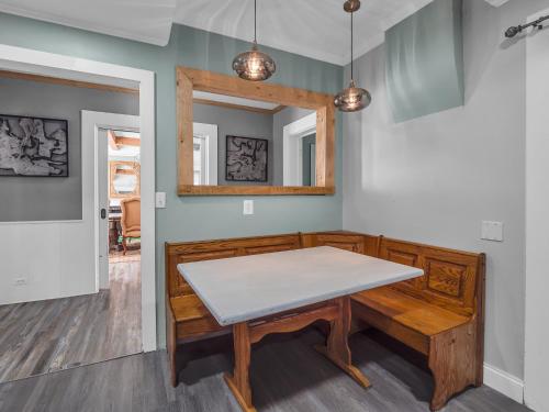 a dining room with a table and a mirror at The Kelly House - 4 BR Historic Lodge - Downtown in Ellicottville