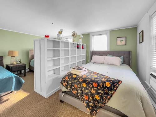 a bedroom with a bed and a white shelf at The Kelly House - 4 BR Historic Lodge - Downtown in Ellicottville