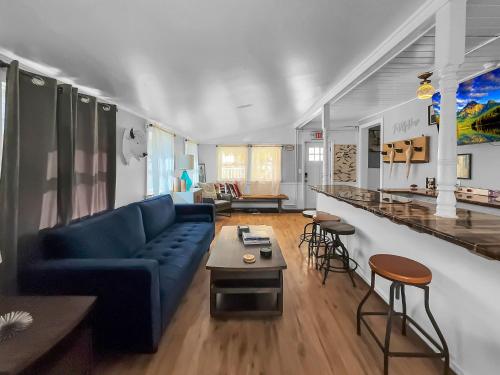 a living room with a blue couch and a table at The Kelly House - 4 BR Historic Lodge - Downtown in Ellicottville