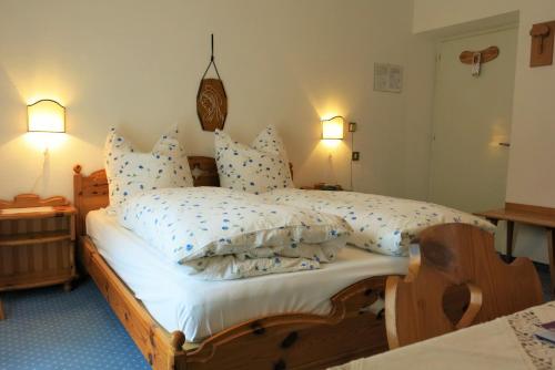 um quarto com uma cama com almofadas em Digonera Historic Hotel B&B em Rocca Pietore
