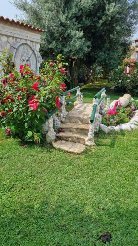 a garden with a stone path with flowers and a bench at La casa dell'artista in Ardea