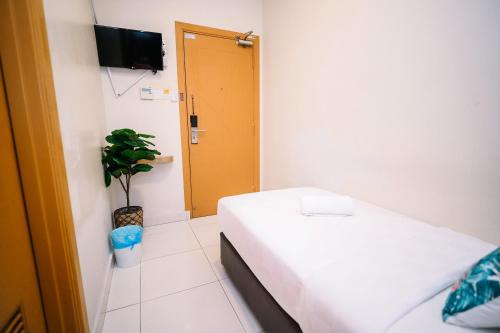 a room with a bed and a door and a plant at Swing & Pillows - PJ21 Petaling Jaya in Petaling Jaya