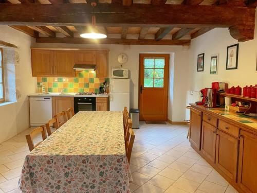 une cuisine avec une table, des chaises et une table ainsi qu'une cuisine avec un comptoir dans l'établissement Gîte tout inclus près de Blois avec jardin, idéal familles, proche châteaux de la Loire - FR-1-491-430, à Orchaise