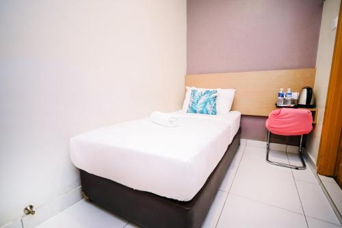 a small room with a bed and a stool at Swing & Pillows - PJ21 Petaling Jaya in Petaling Jaya