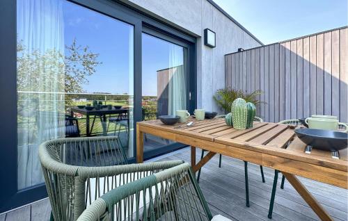 a wooden table and two chairs on a balcony at 2 Bedroom Beautiful Apartment In Bièvre in Bièvre
