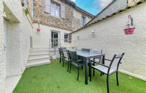 un patio avec une table et des chaises sur l'herbe dans l'établissement Beautiful Home In Pélussin With Kitchen, à Pélussin