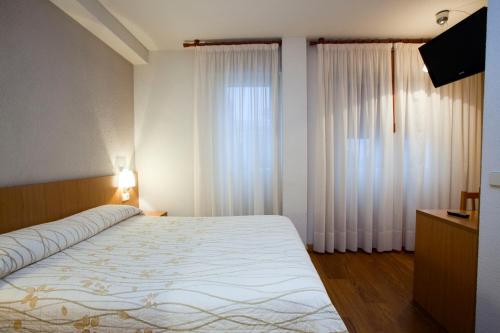 Un pat sau paturi într-o cameră la Hostal Abodi